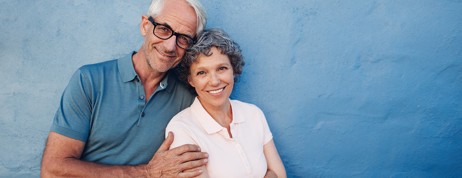 Smiling couple in front of a blue wall