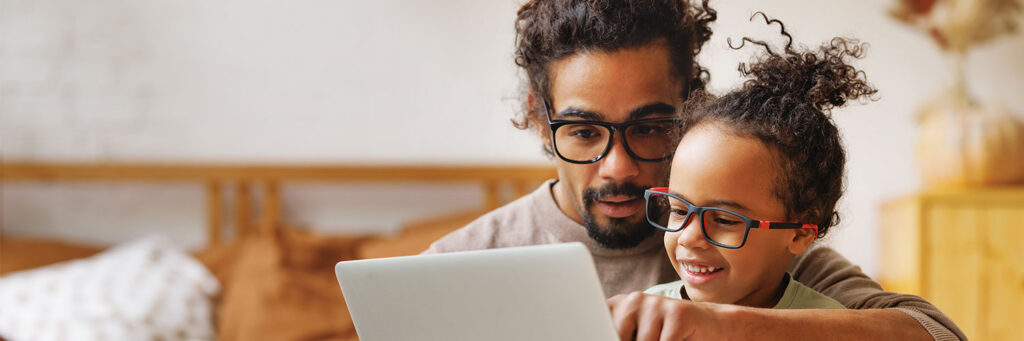 fundraiser-call-to-action Father and daughter with glasses looking at laptop screen together to fundraise for glaucoma